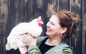 Inga mit Huhn vor Holzwand