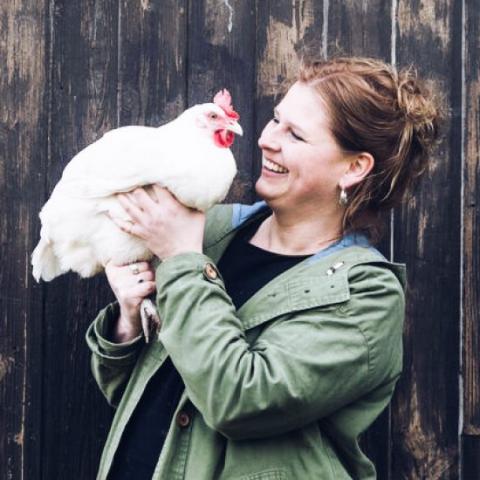 Inga mit Huhn vor Holzwand